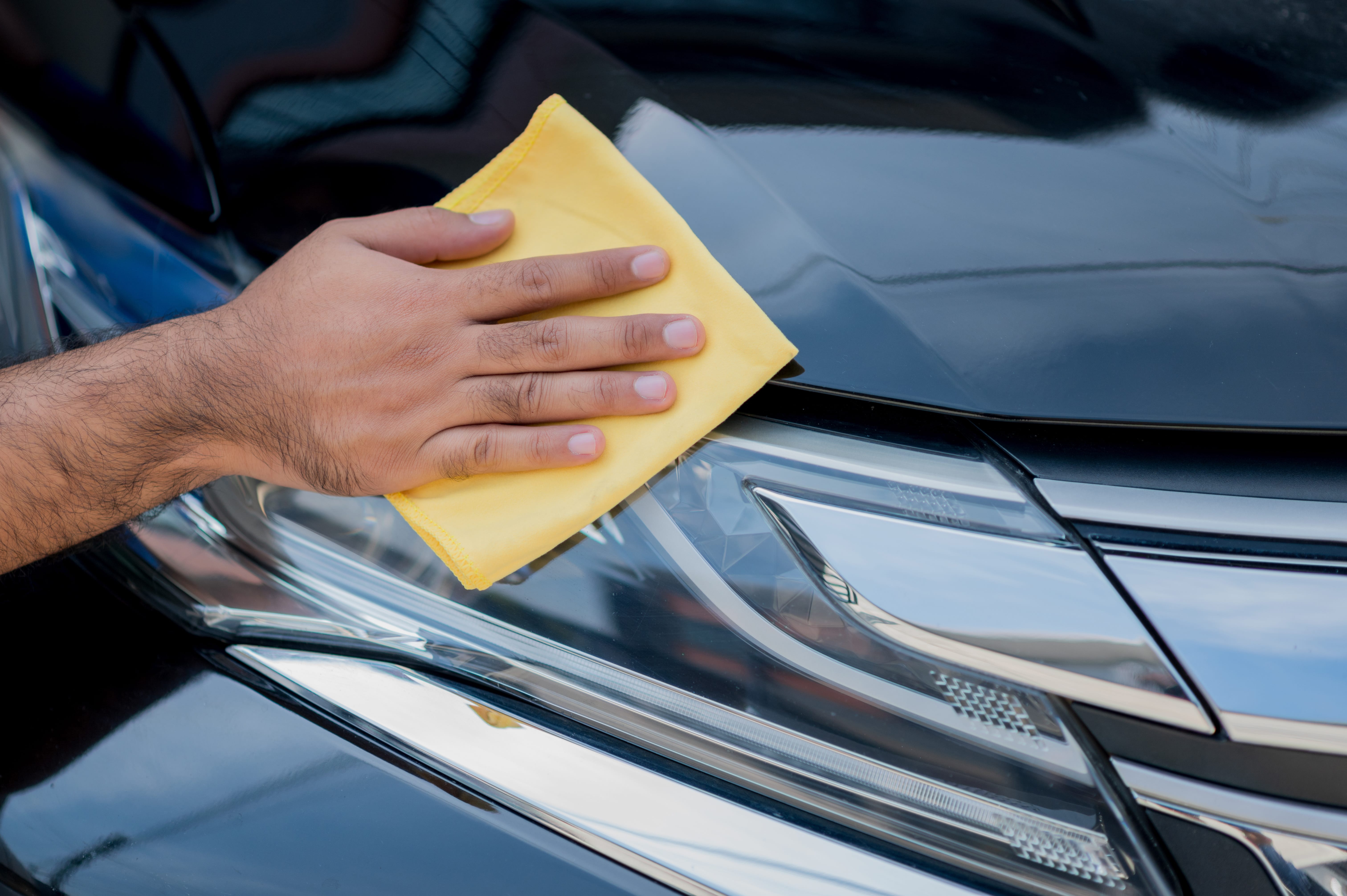 Person cleaning car headlights