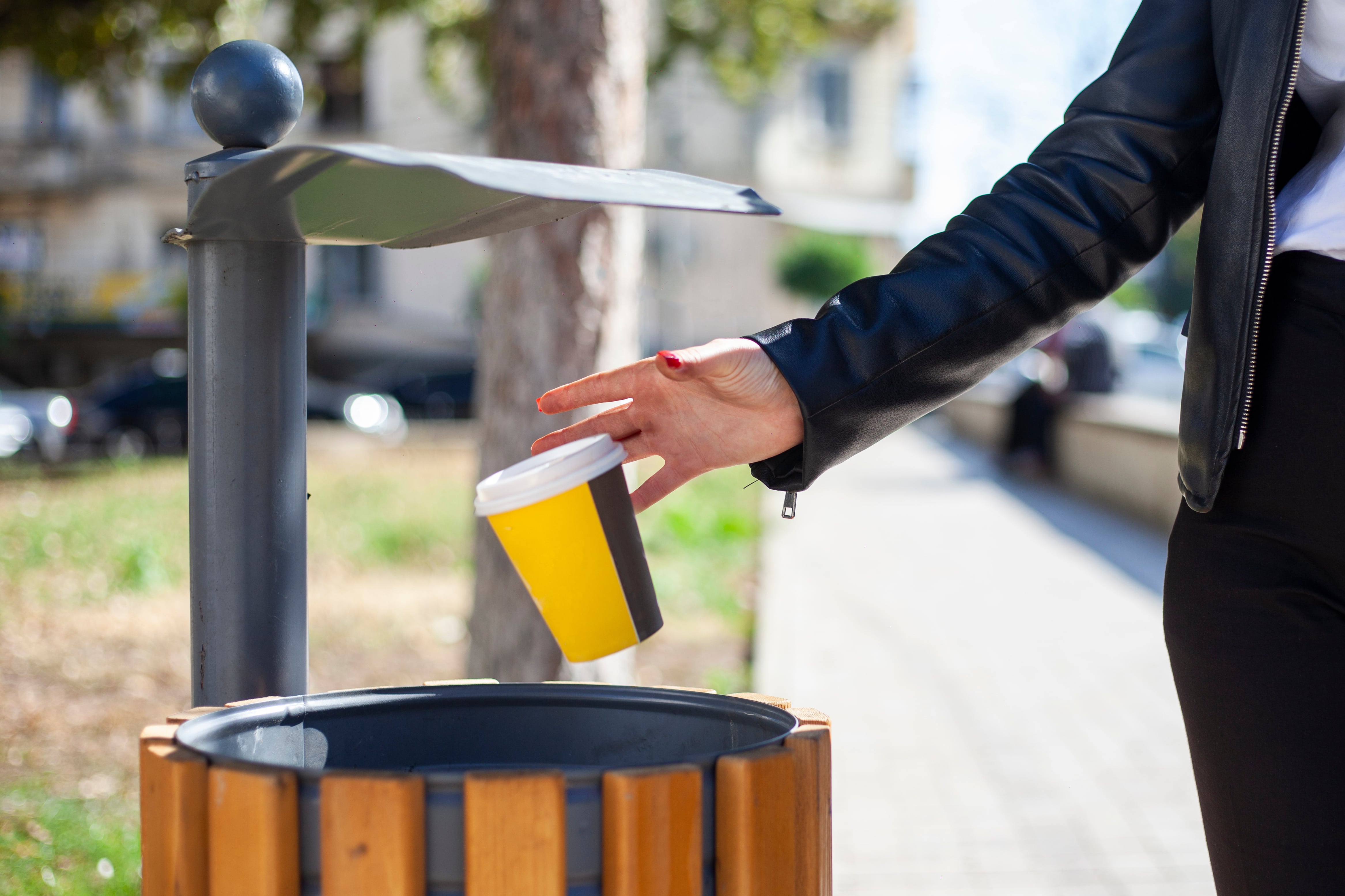 Girl throwing a coffee can in trash can