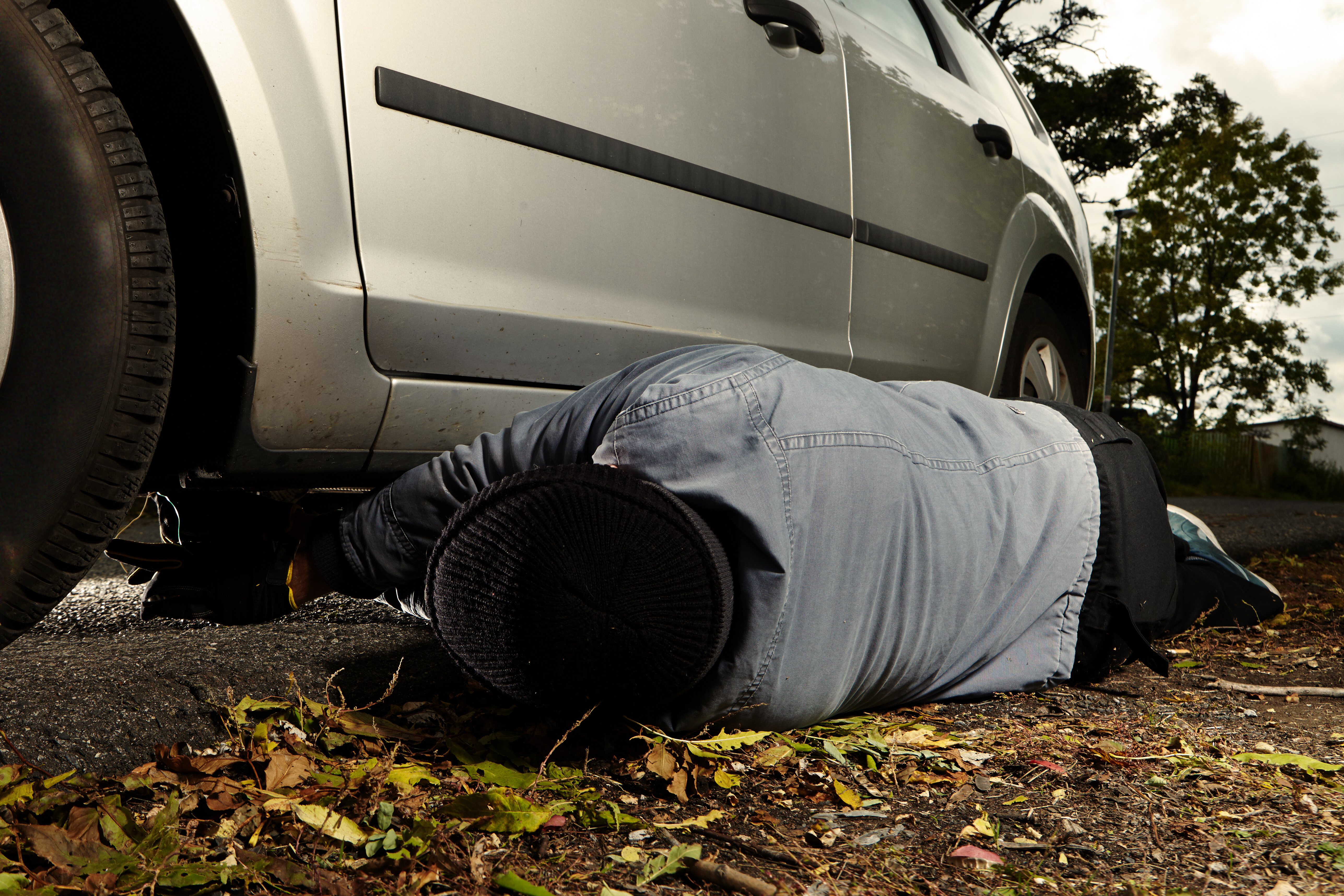 Person checking under car