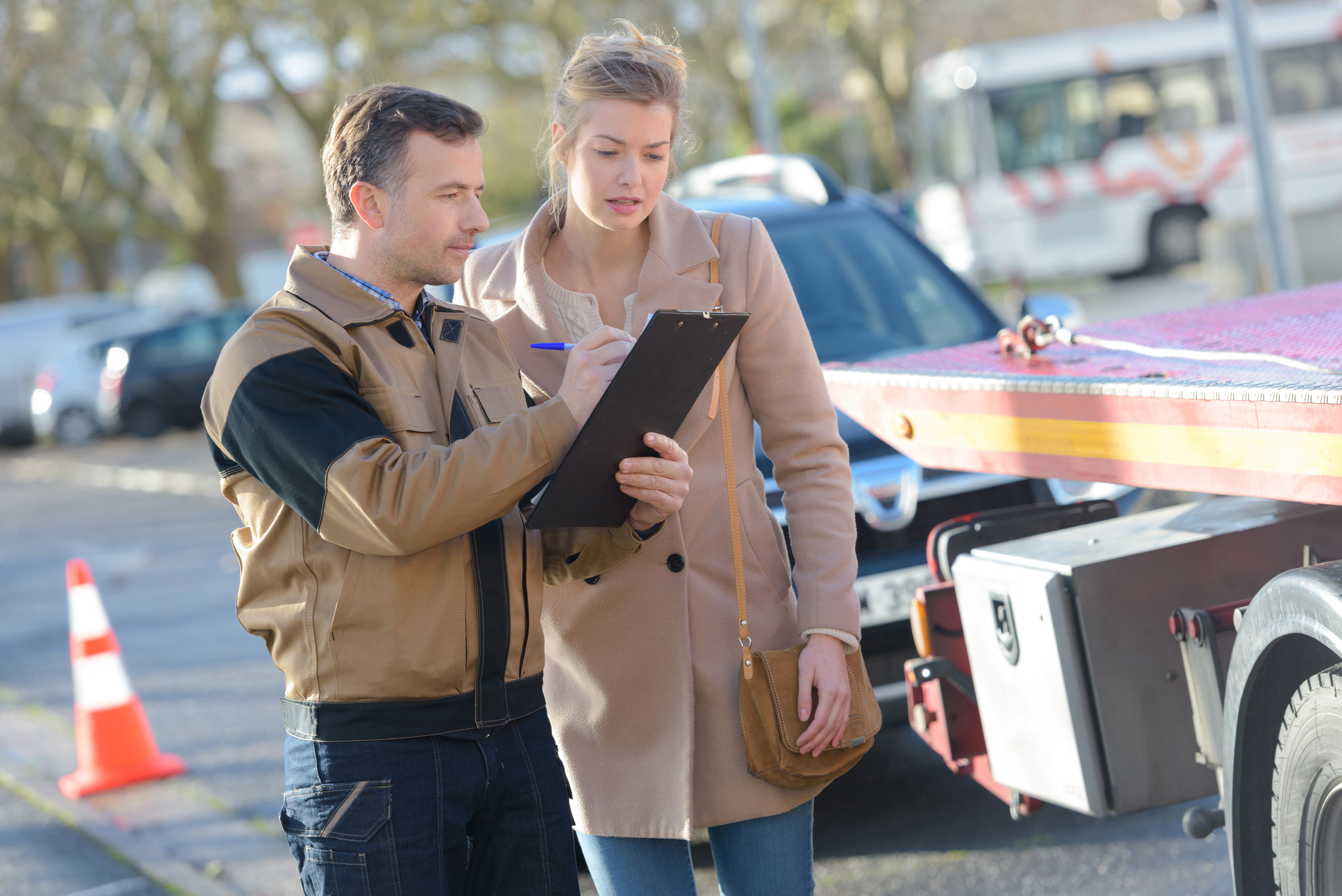 Tow truck driver with customer and paperwork