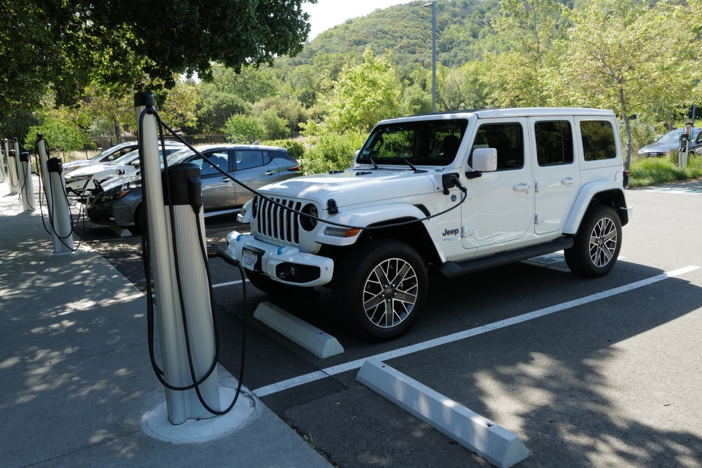 A 2022 Jeep Wrangler 4xe electric vehicle is parked while being charged.
