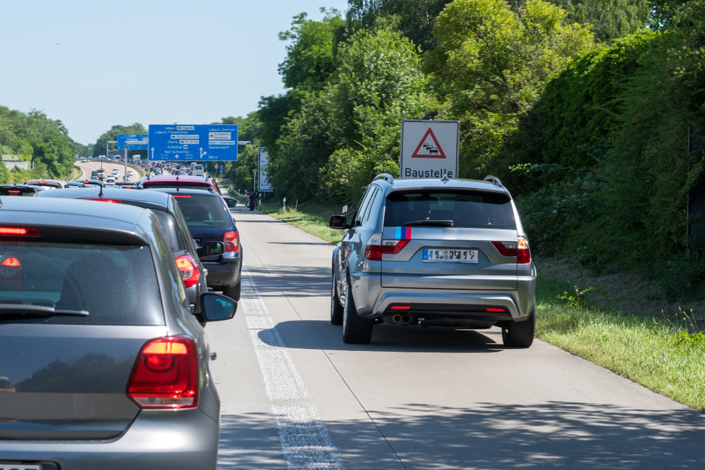 Car drive on side lanes on the right side of the traffic jam.