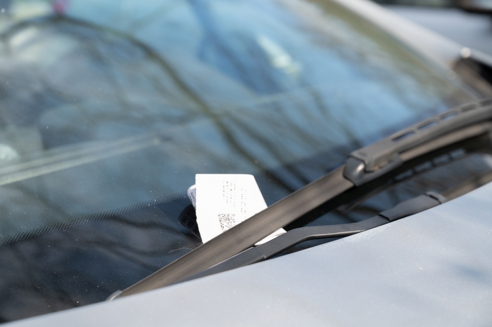 A note under the windshield wiper.