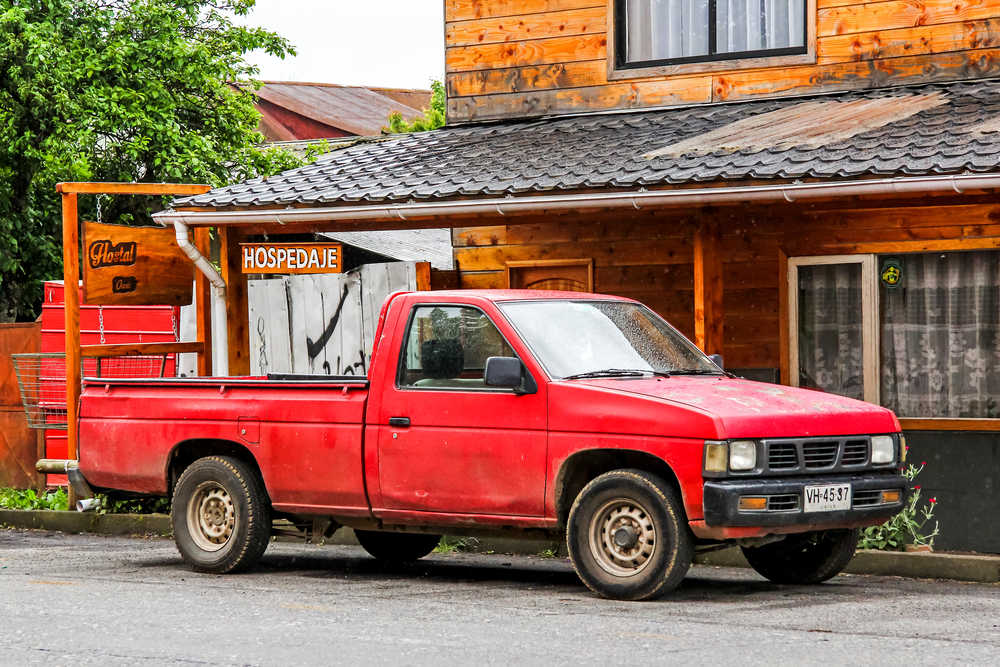 Red pickup truck Nissan Hardbody in the city street - 2015