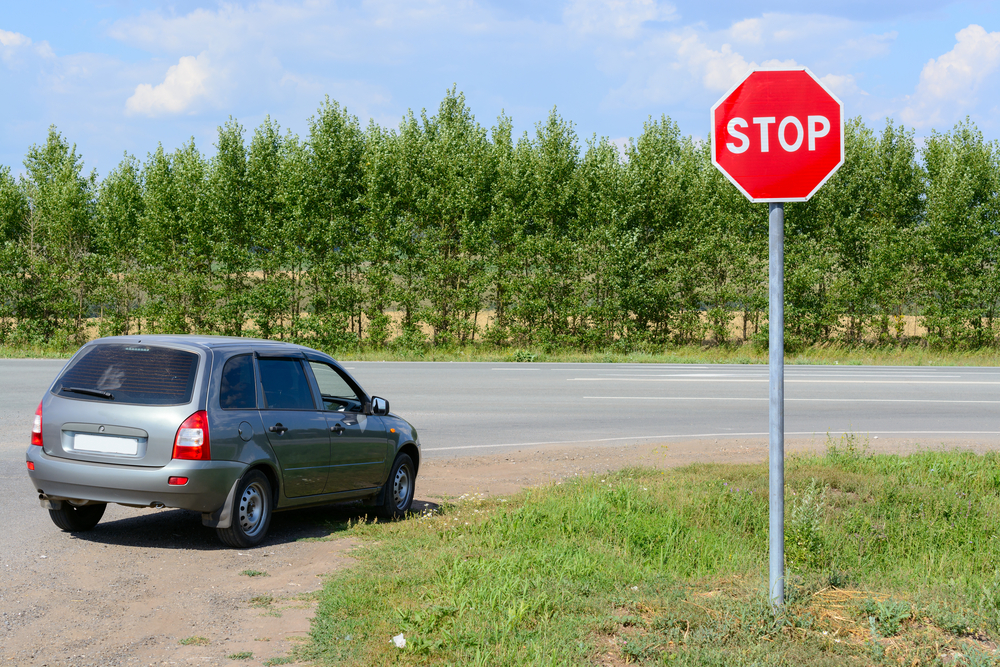Stop sign on the road and a car