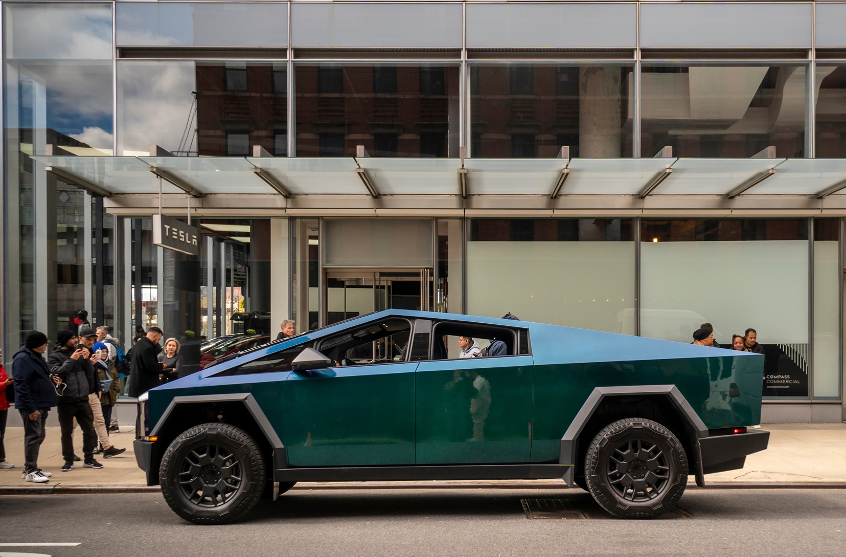 Automotive enthusiasts ogle Tesla Cybertrucks on display outside the Tesla showroom - 2024