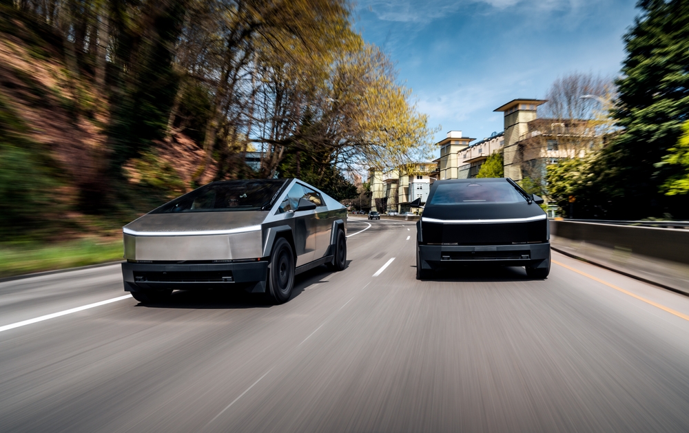 2024 Tesla Cybertrucks driving together on the road.