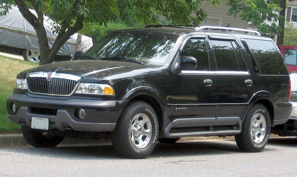 A close-up photo of a Black 1998 Lincoln Navigator car parked on a city street