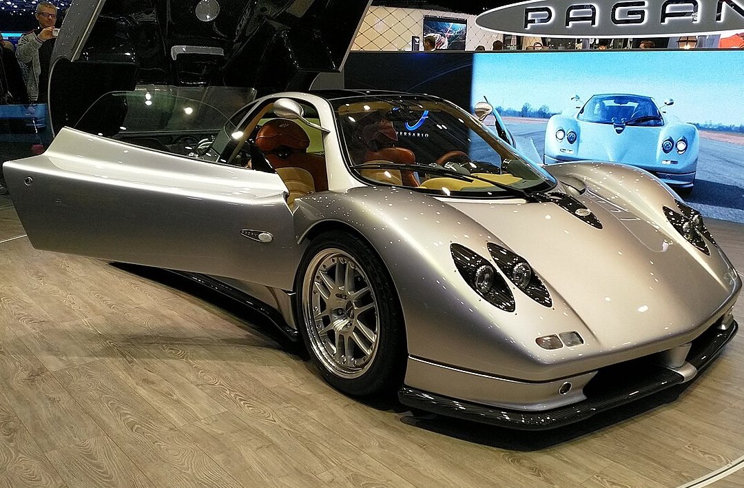 A close-up photo of a Silver 1999 Pagani Zonda car on display at an exhibition