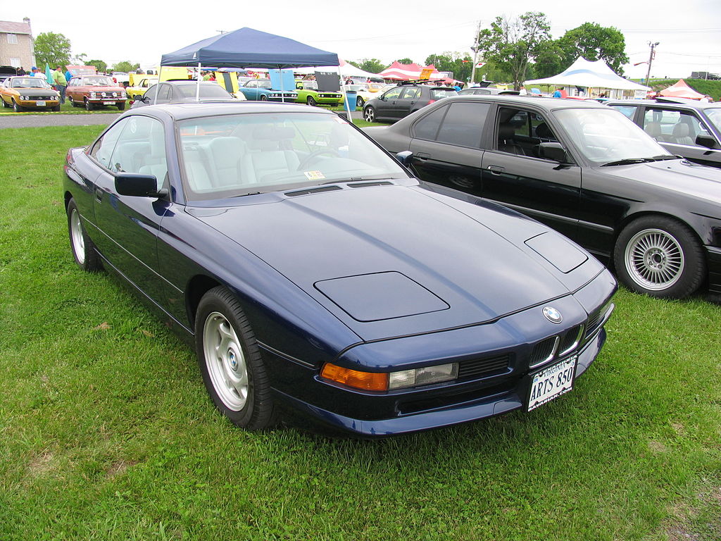 A close-up photo of a Dark Blue 1991 BMW 8-Series car on display at an exhibition