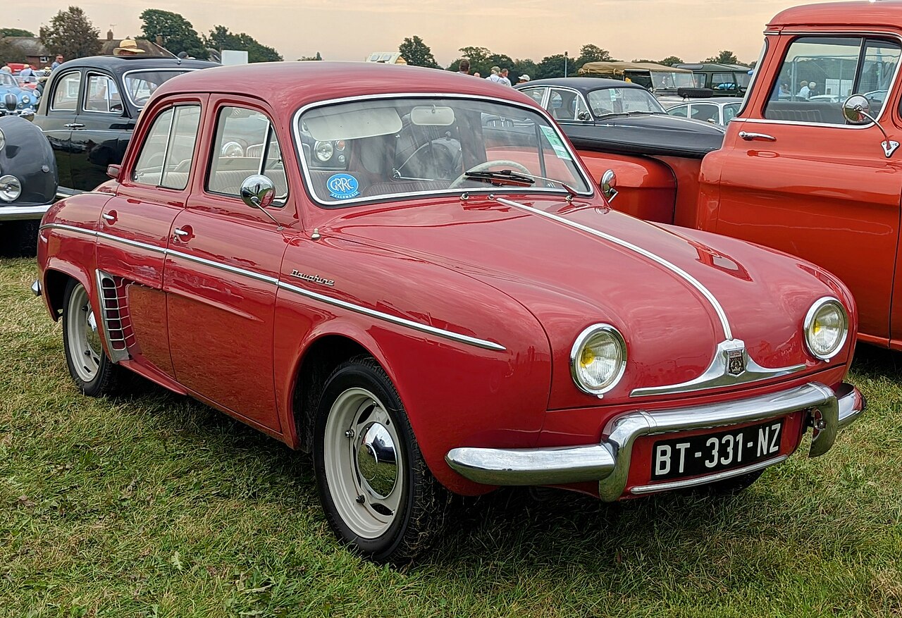 Red Renault Dauphine outside.