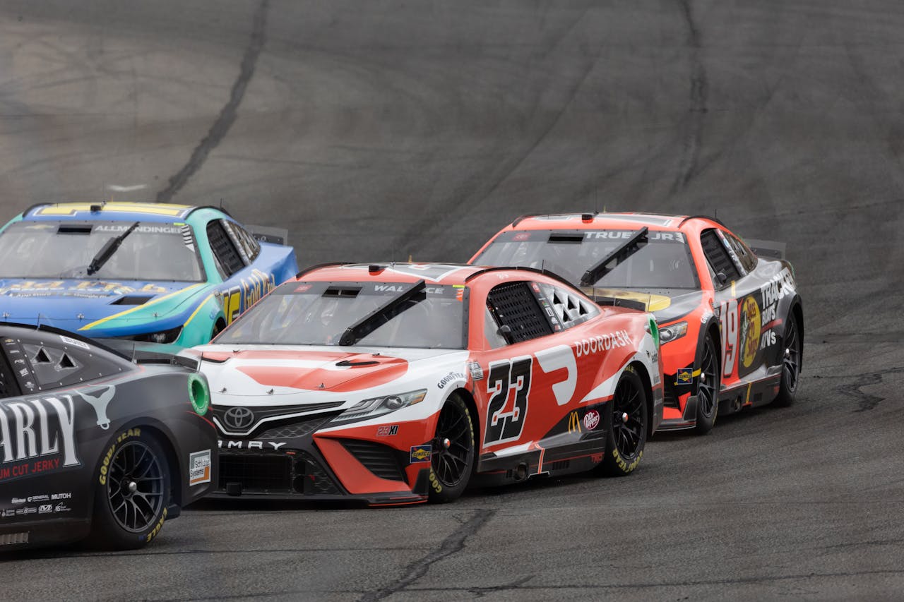 A couple of racing cars driving down