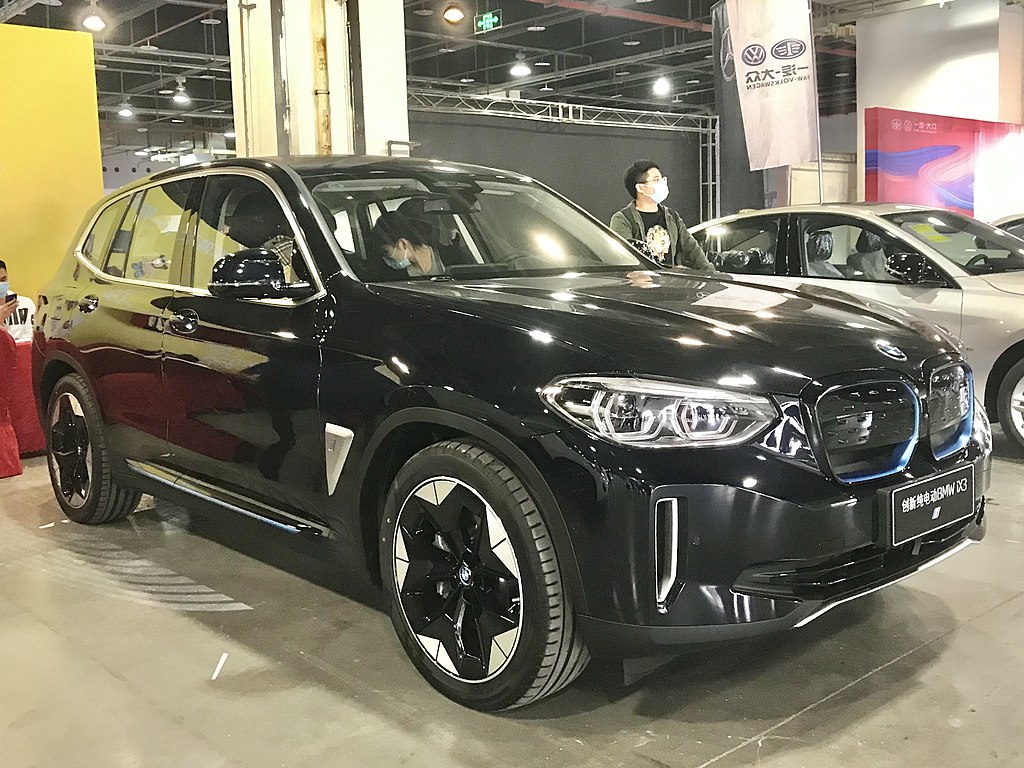 A close-up photo of a Black BMW iX3 car on display at an exhibition