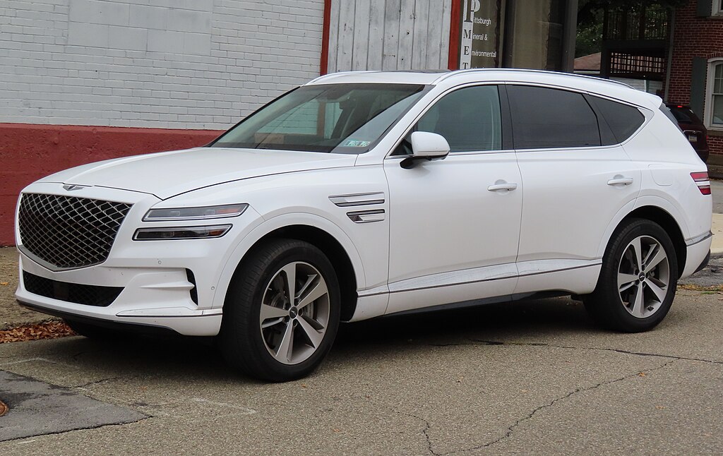 A close-up photo of a White 2021 Genesis GV80  car parked on a city street