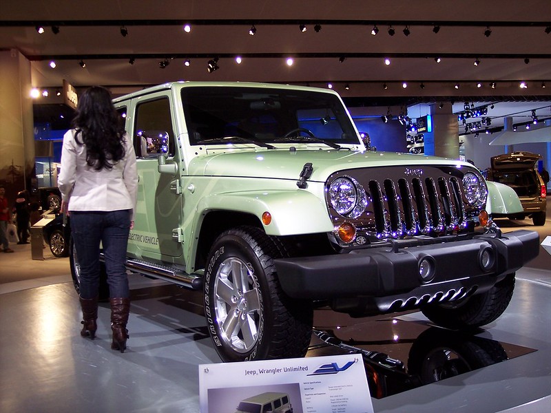 A close-up photo of a Green Jeep Wrangler EV car on display at an exhibition