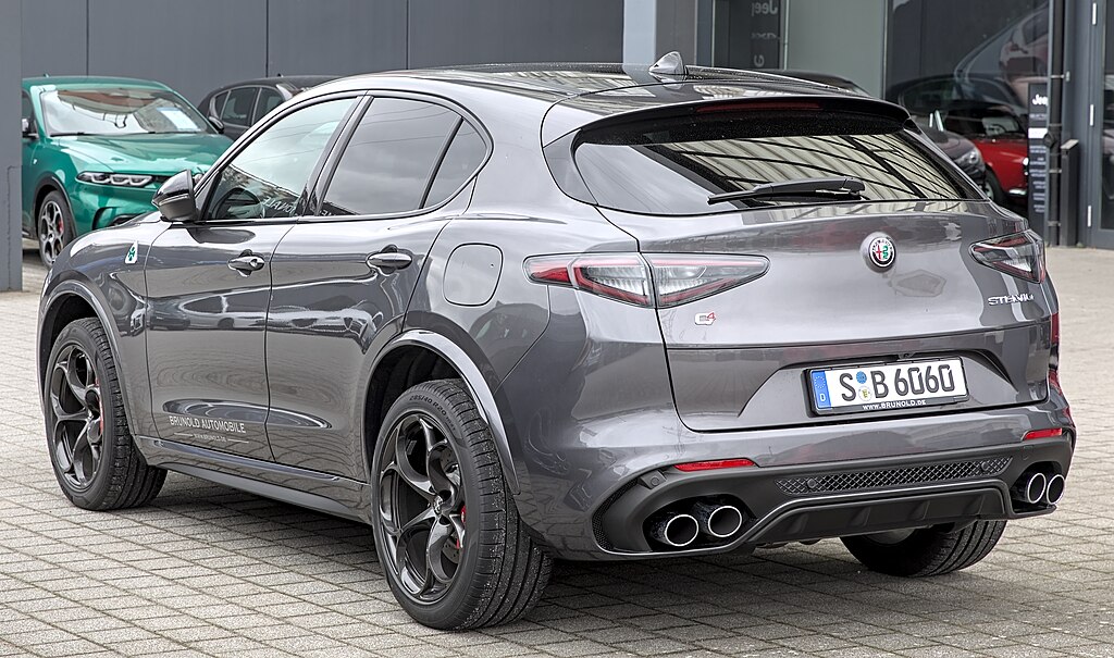 A close-up photo of a Silver Alfa Romeo Stelvio car parked in a parking lot