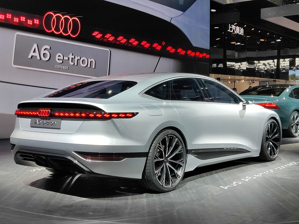 A close-up photo of a White Audi A6 E-Tron car on display at an exhibition