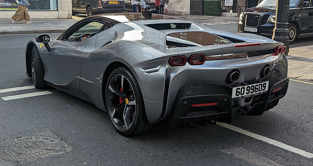 A close-up photo of a silver Ferrari SF90 Stradale car parked on a city street