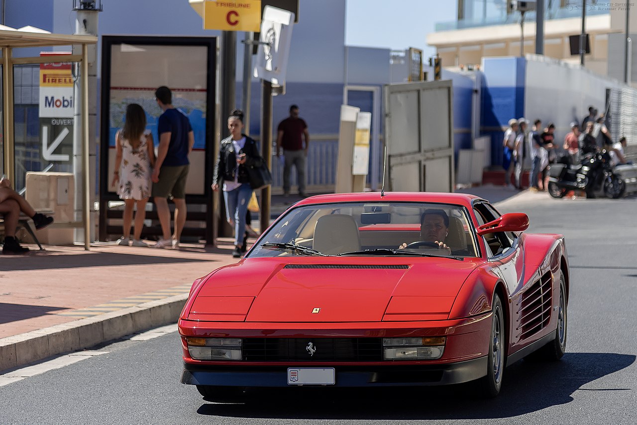 Red Ferrari Testarossa driving on the street.
