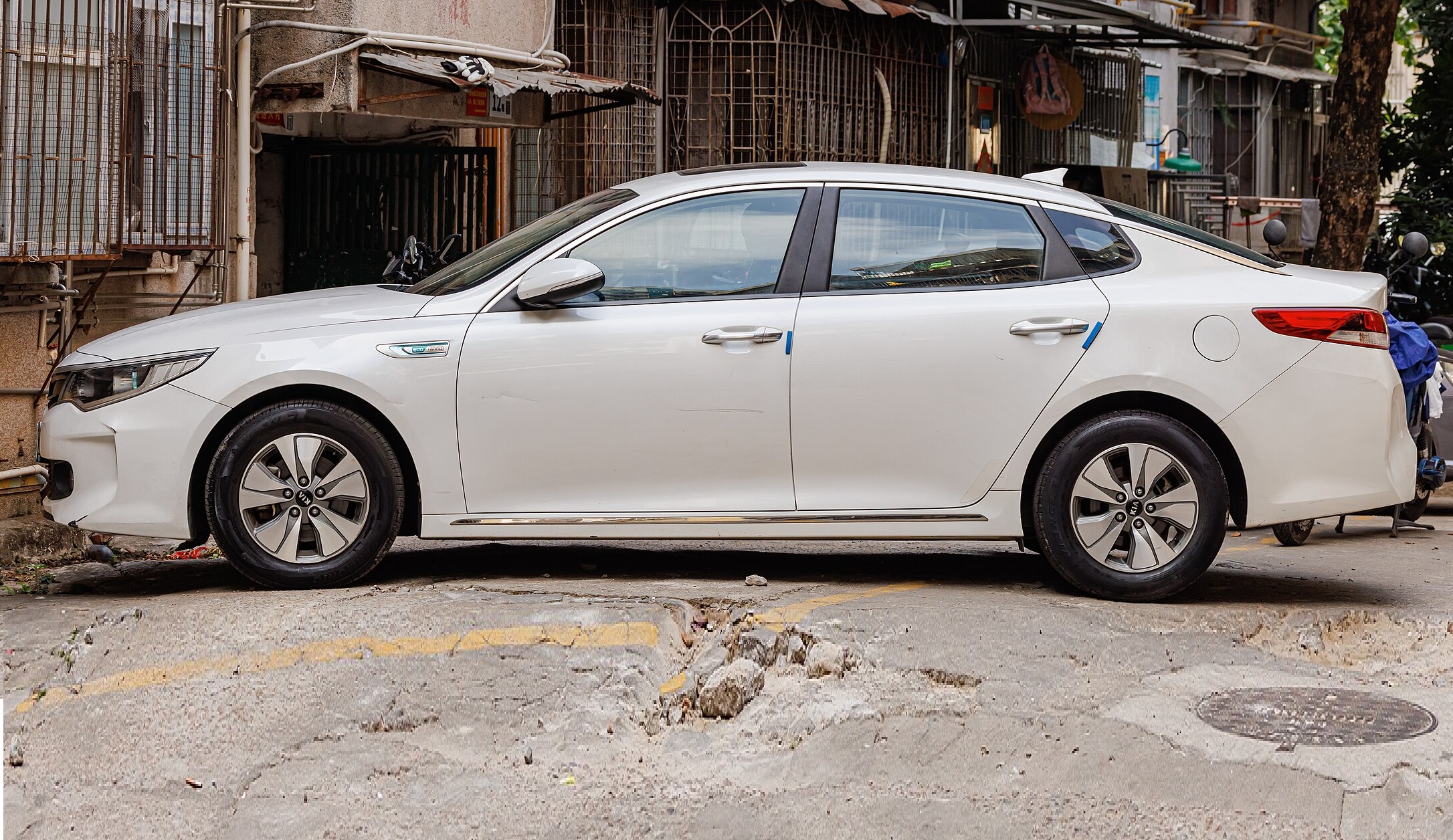 White Kia K5 Hybrid - side view.