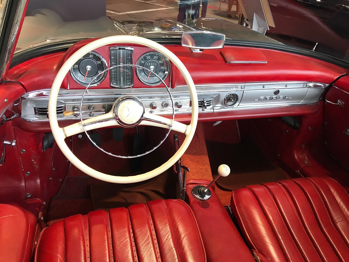 Dashboard and white steering wheel and bright red leather interior of classic Mercedes-Benz vintage 1958 300SL silver convertible roadster