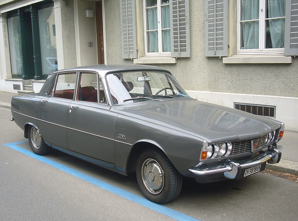 Close Up Photo of gray Rover P6 parked in front of a building.