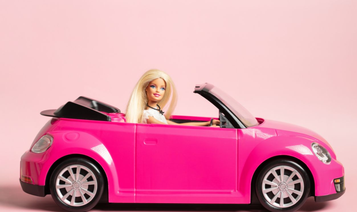 Grodno, Belarus - July 30, 2023: Plastic Barbie doll with blonde hair driving a pink car.