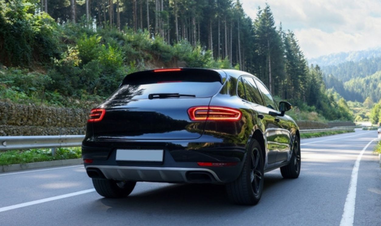 Picturesque view of asphalt road with modern black car