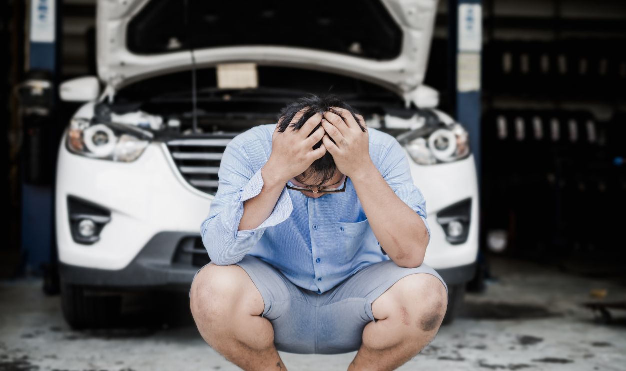 Stressed man in front of car