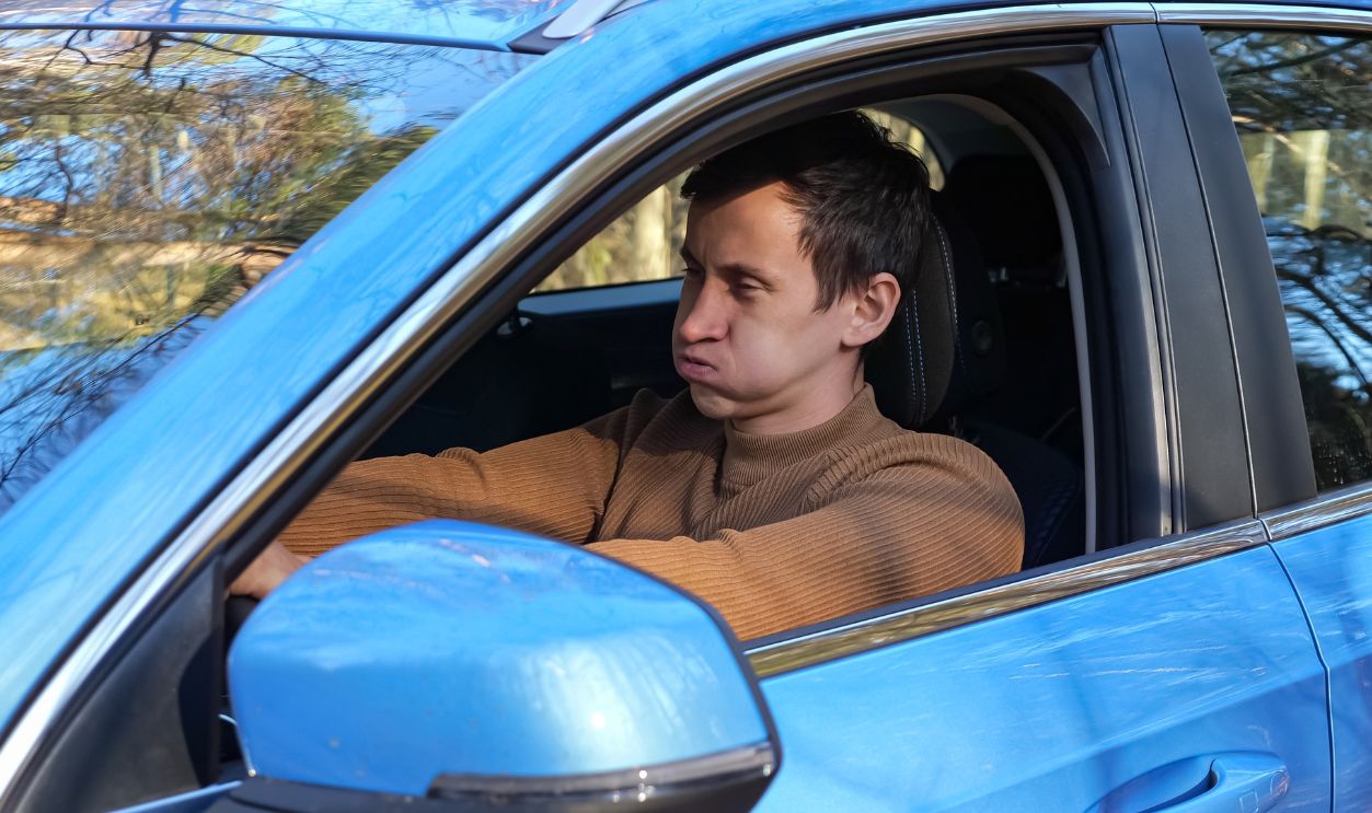 Stressed man driving new car