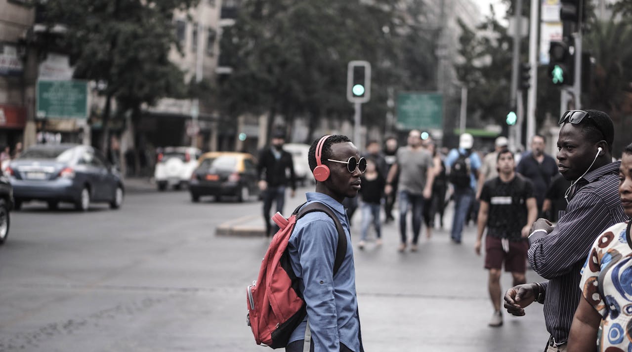 Photo of Man Wearing Headphones on the street.