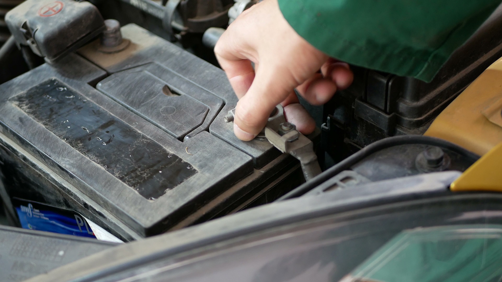 Male hand, disconnecting the terminals from the car battery.