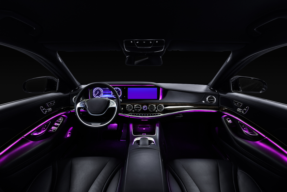 Black leather cockpit with violet ambient light in the car.