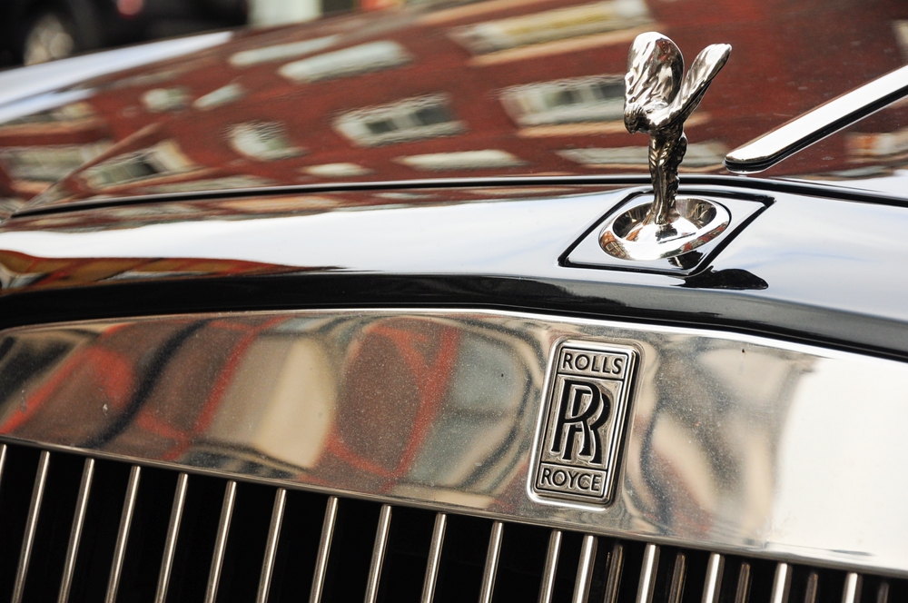 Photo of a Rolls-Royce emblem with city reflections