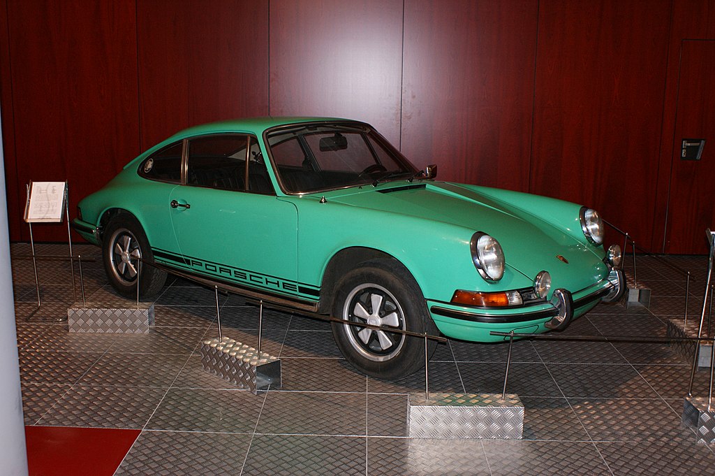 A close-up photo of a Green 1973 Porsche 911T car on display at an exhibition