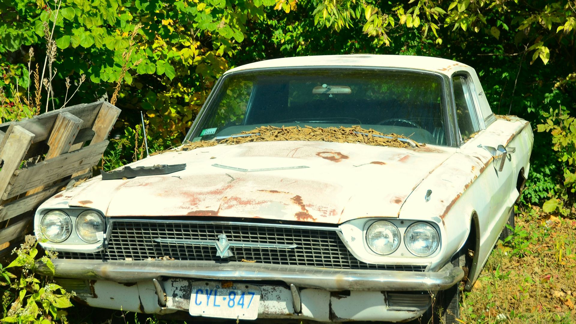 an old car is sitting in the grass