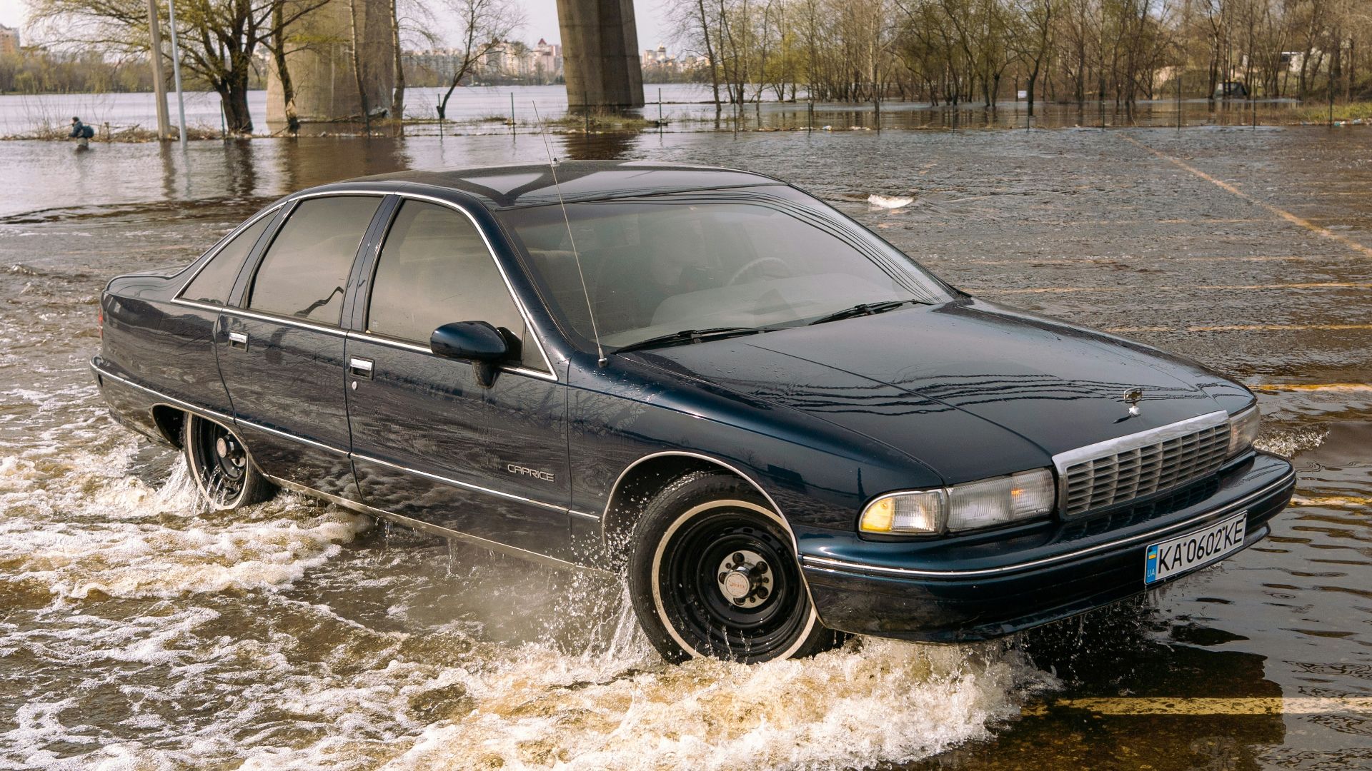 a car driving through a flooded parking lot