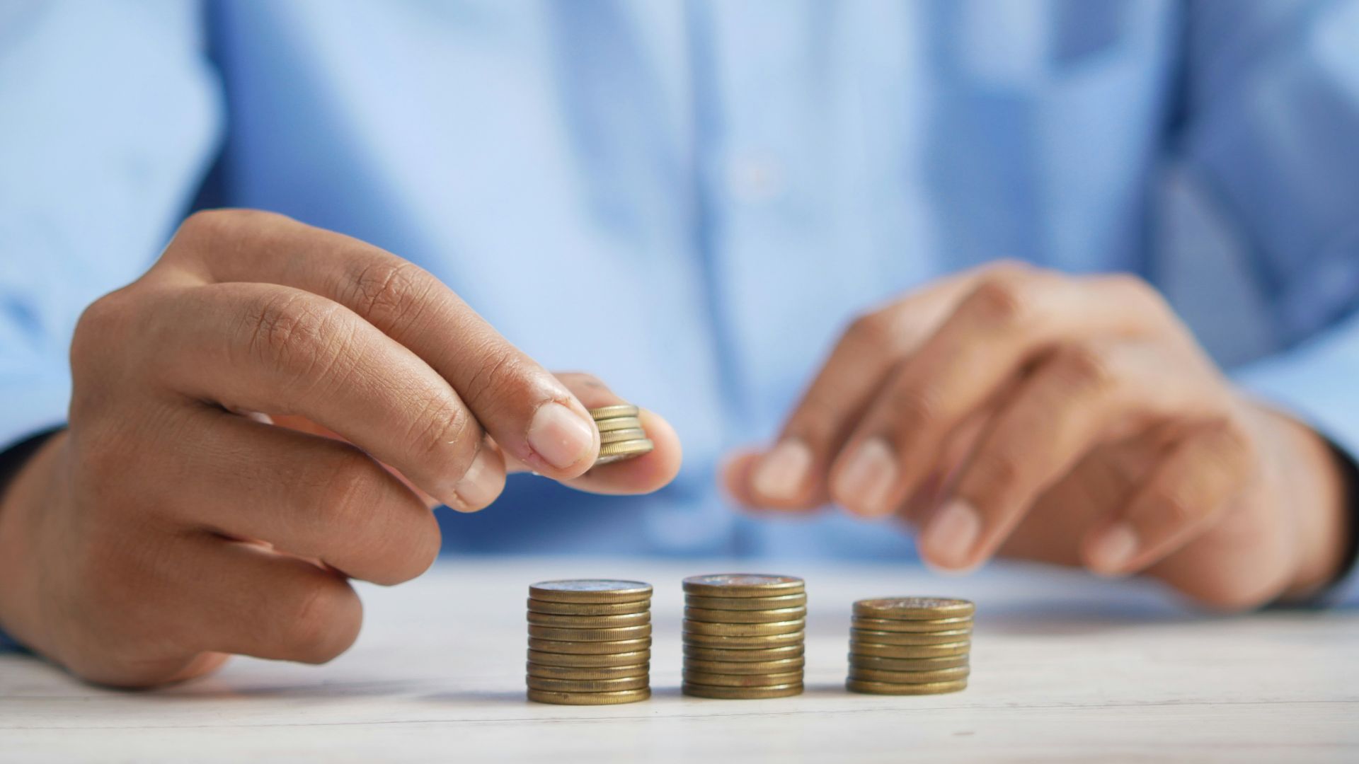 a person stacking coins on top of a table