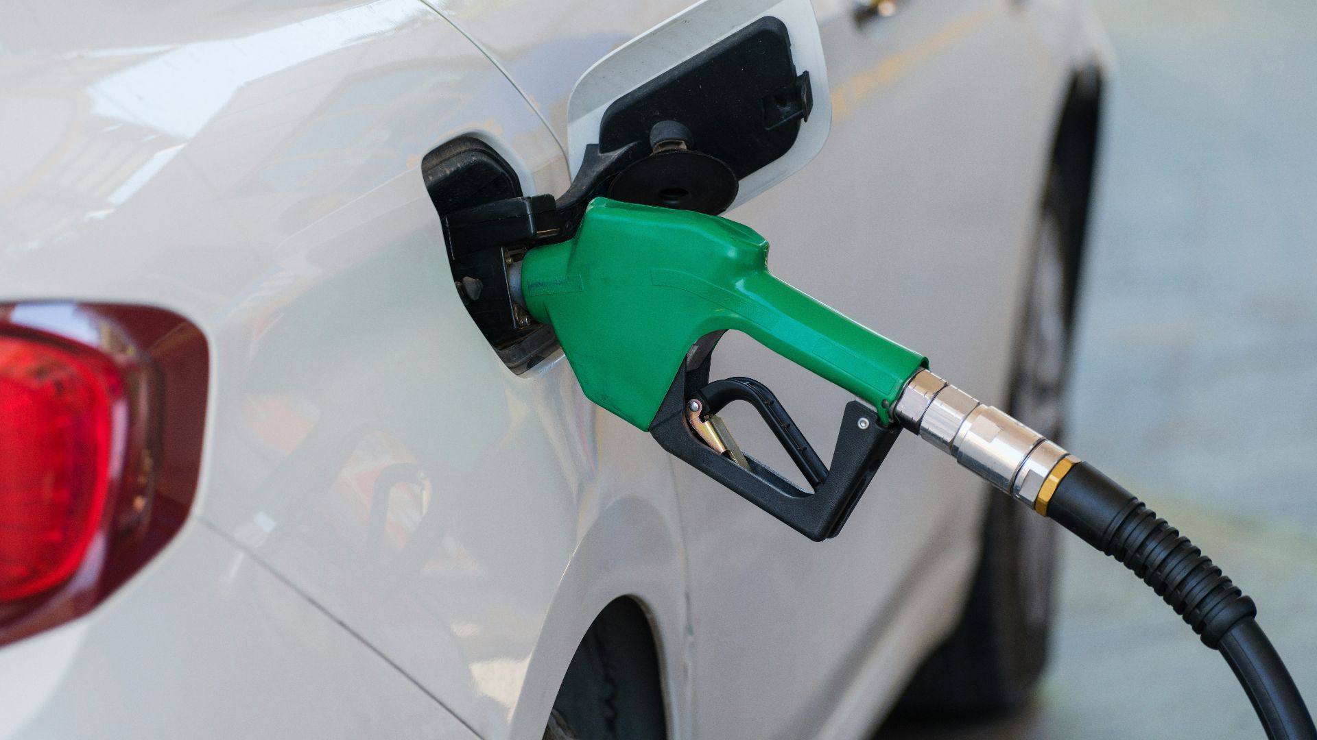 a white car with a green gas pump
