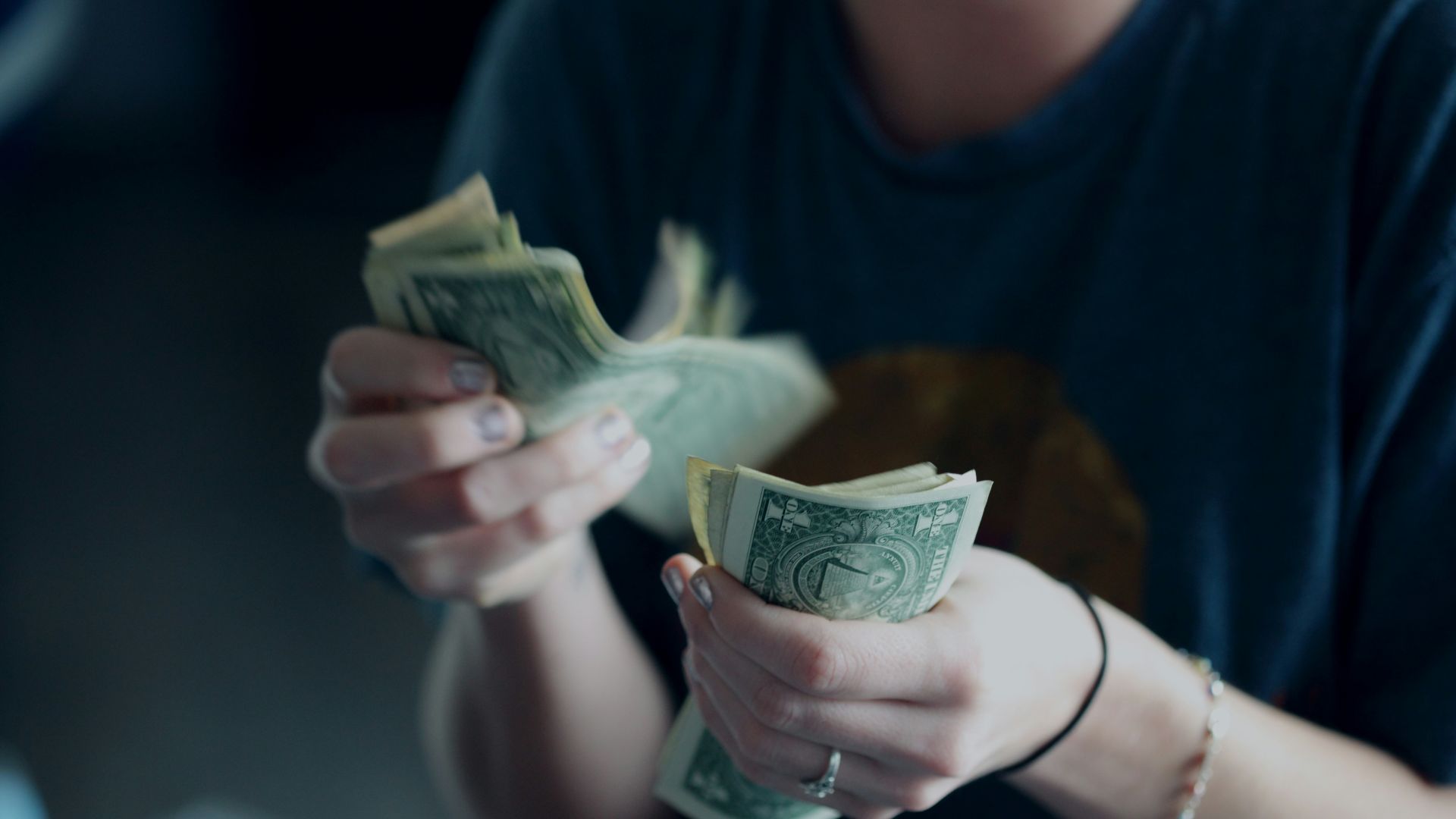 focus photography of person counting dollar banknotes