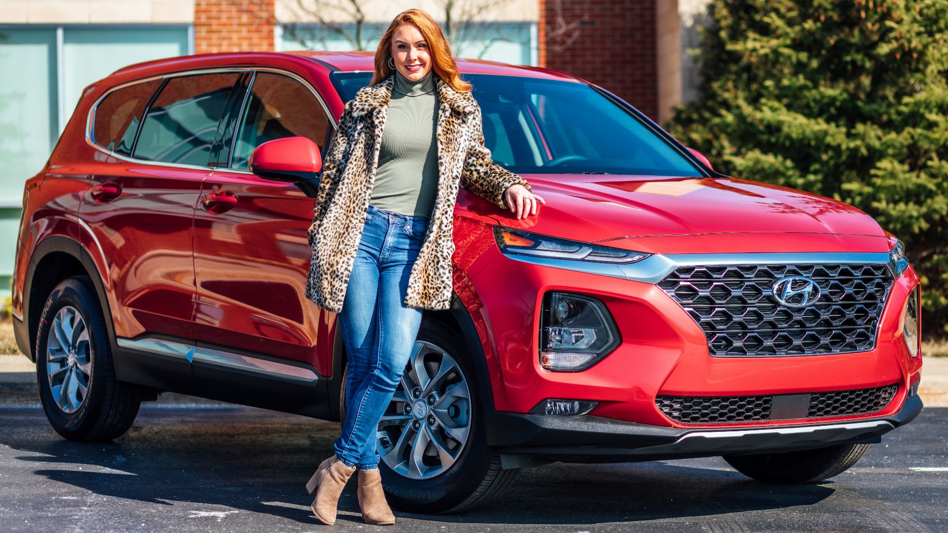 woman in white and black scarf and blue denim jeans standing beside red mercedes benz car