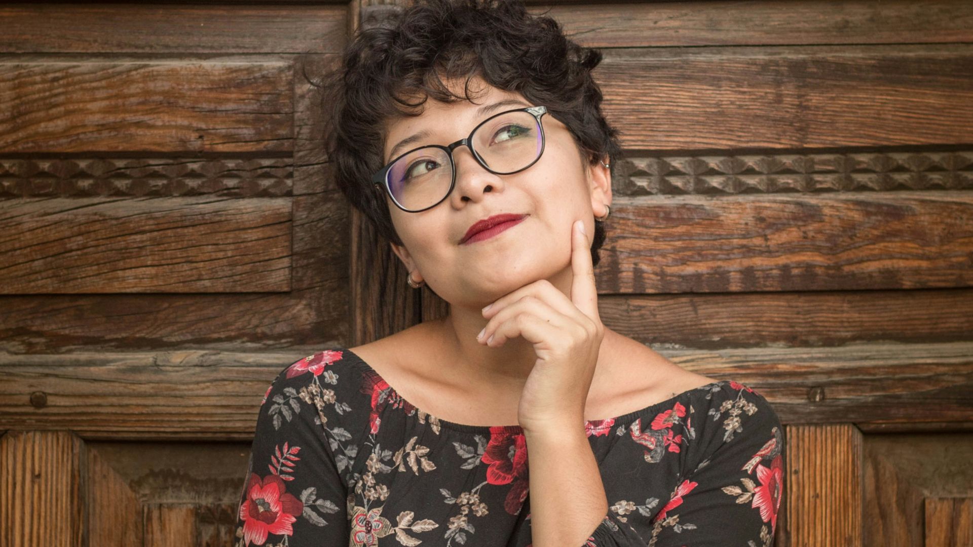 woman leaning against door while holding her cheek