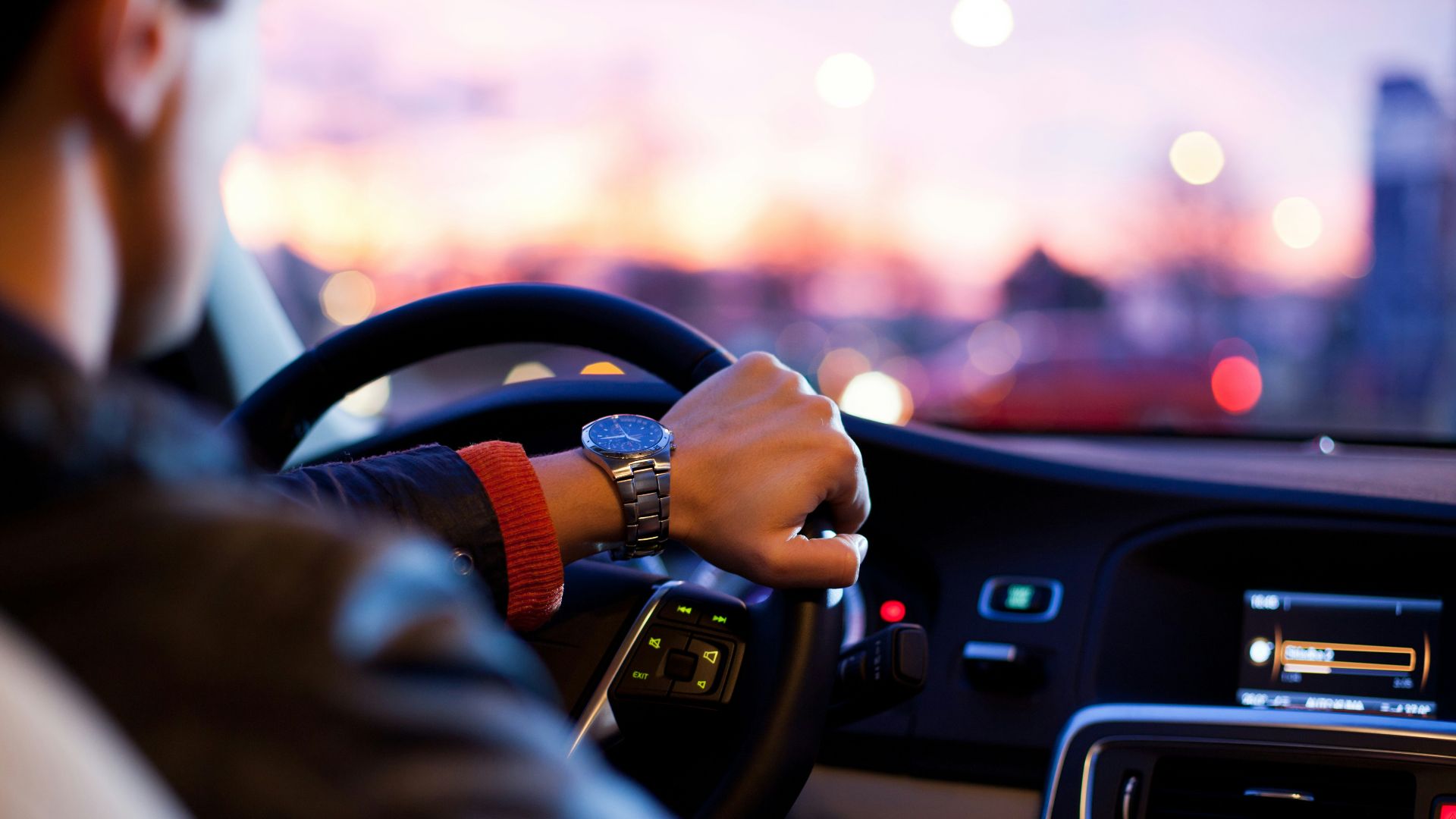 man driving a car wearing wrist watch