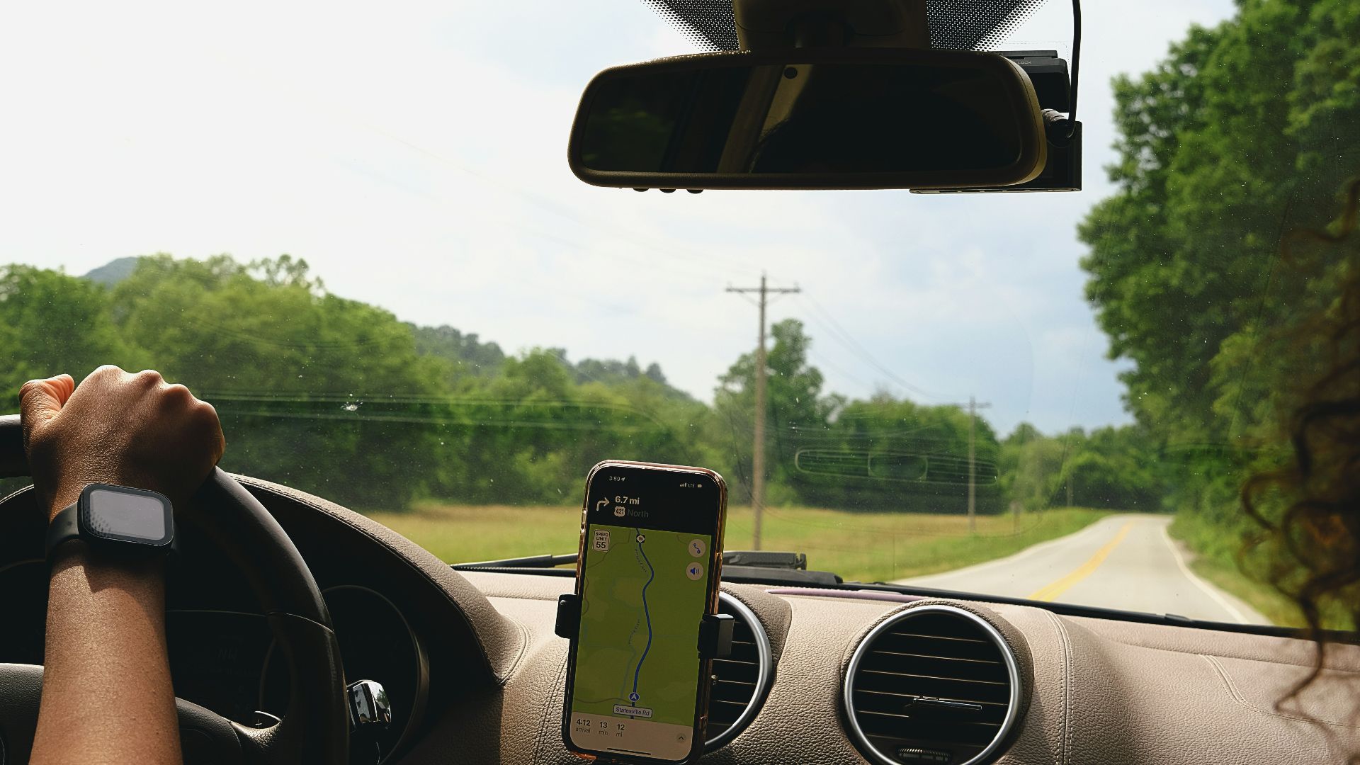 a woman driving a car with a cell phone in her hand
