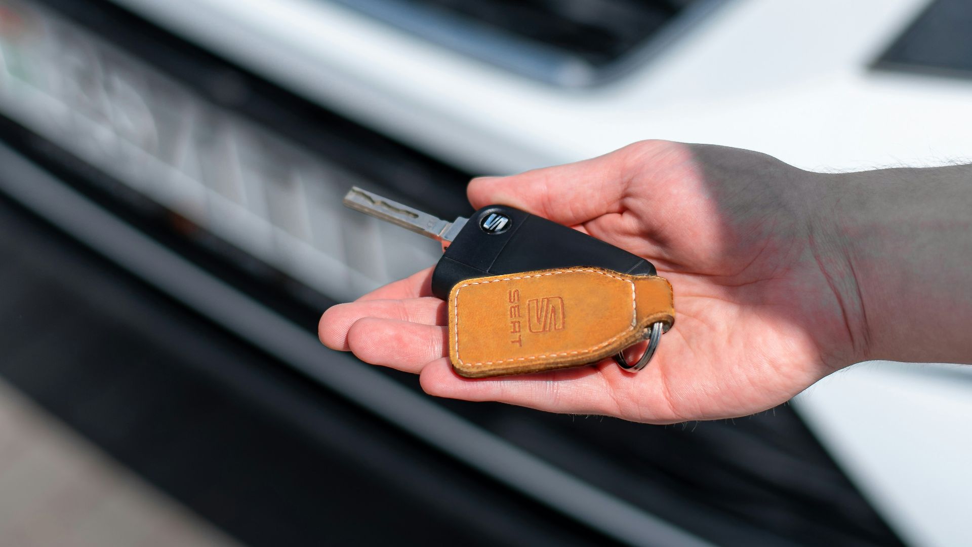 a person holding a car key in their hand