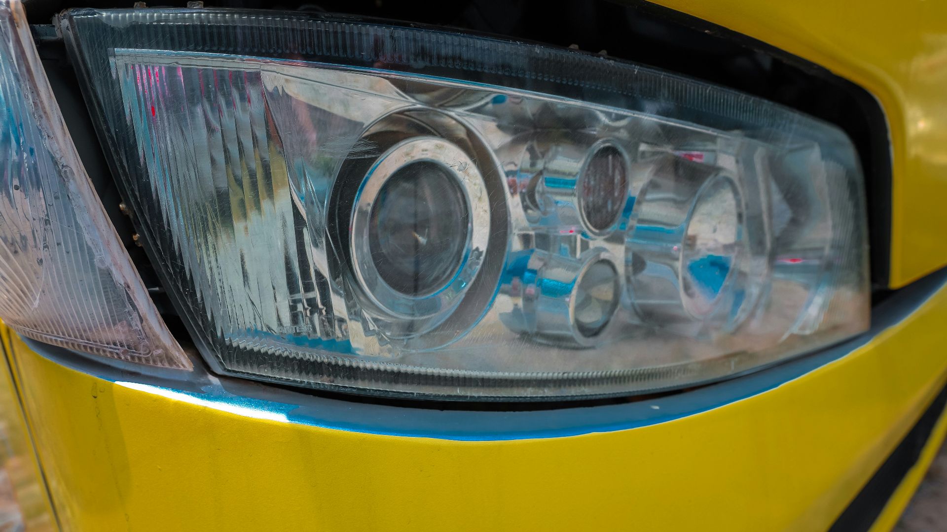 a close up of a headlight on a yellow car