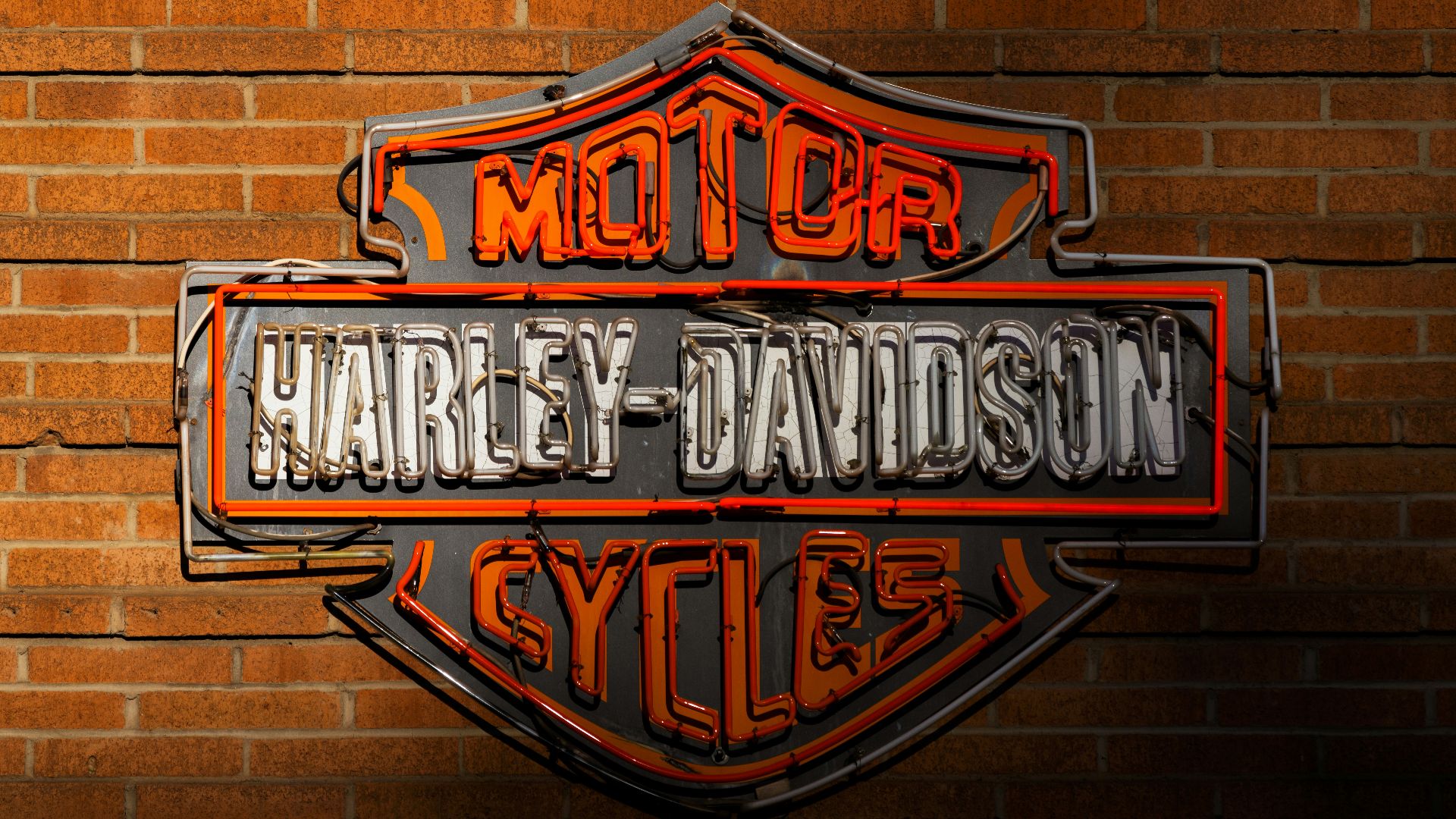 a harley davidson sign on a brick wall