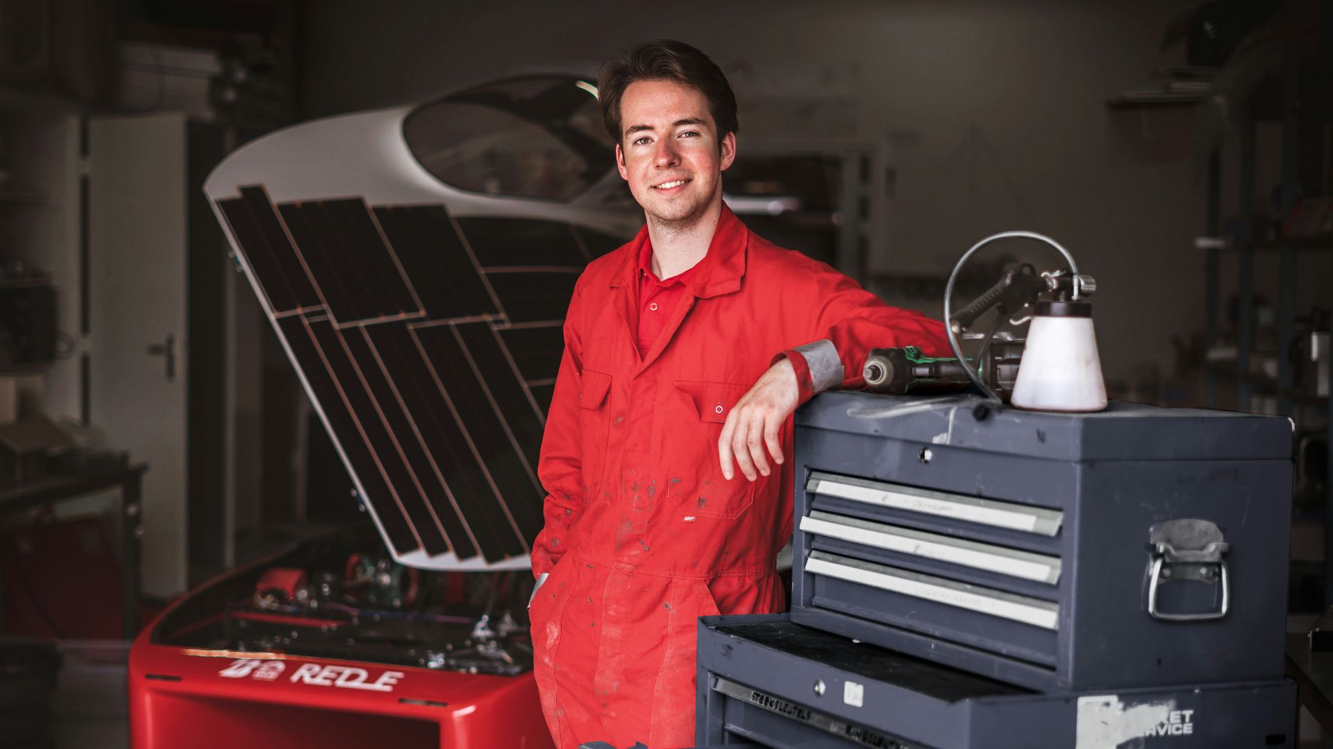a man standing next to a toolbox in a garage