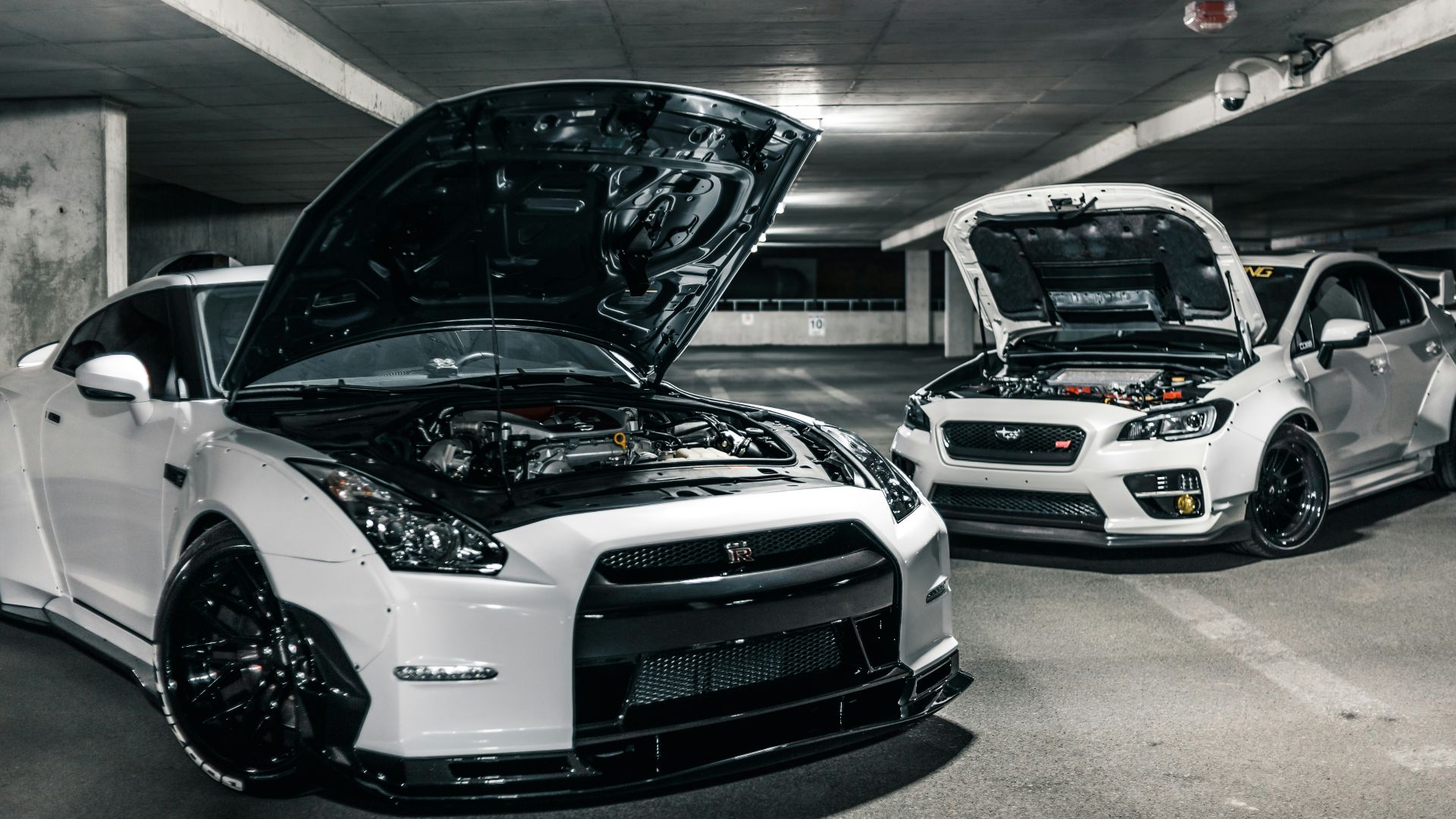 two white cars with open hoods