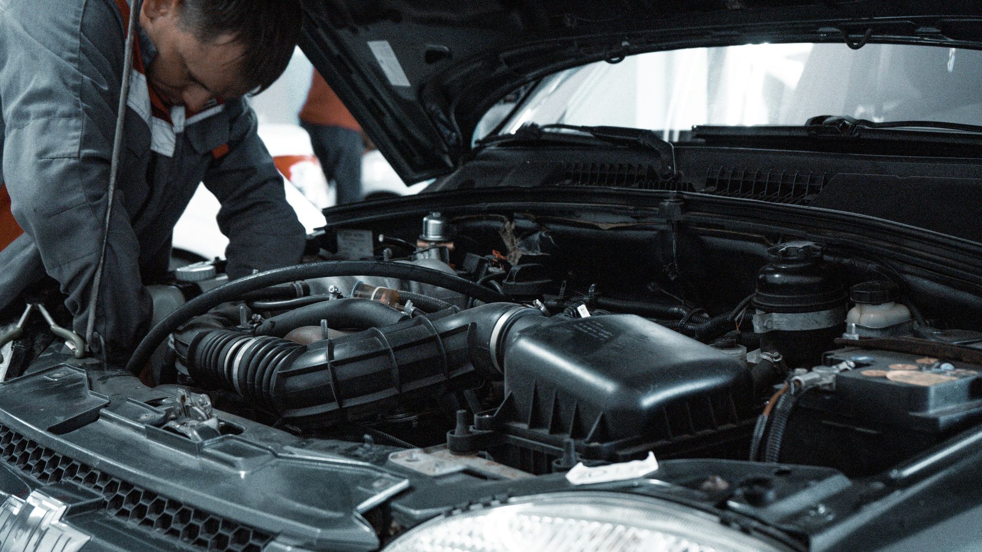 man in white shirt standing beside black car